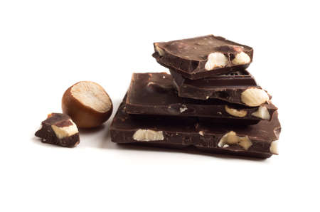 Chocolate with hazelnuts on a white background.の写真素材