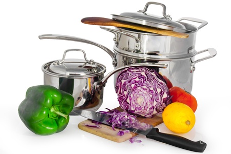 Steam shiny metal saucepan complex isolated in white with vegetables and fruit ready to be chopped with a knife on a piece of woodの写真素材