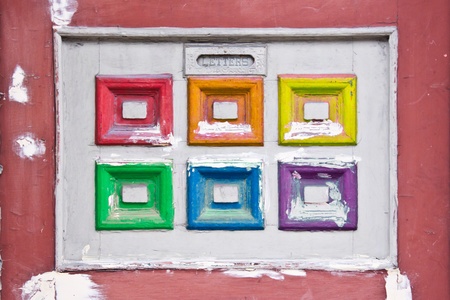 Detail of an vintage door how had a letters window and a white and rainbow square decoration, each square in another color of the rainbowの写真素材