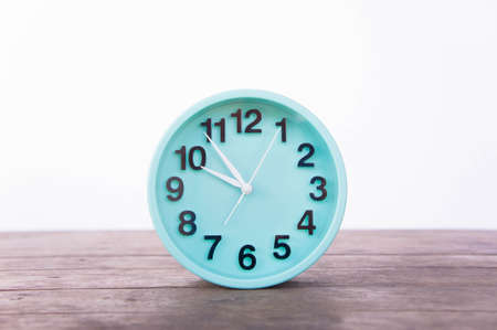 The clock on wooden table and white background vintage style