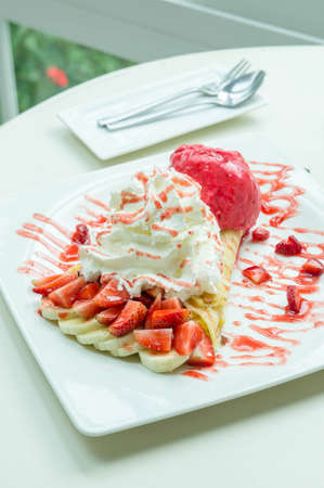 ice cream strawberry crepe dessert on white dish wood table in cafe coffee shop sweet foodの写真素材