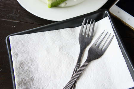 two Fork on a tissue tray in a cafe.