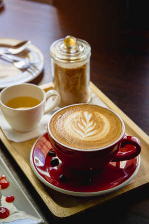 latte coffee red cup and cake on the wood table in the coffee shop cafeの写真素材