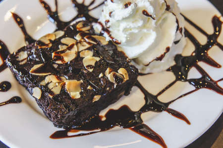 brownie cake and creamy dessert on white dishの写真素材