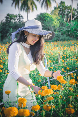 beautiful woman asia style on yellow flower garden and looking smile happy time on the day