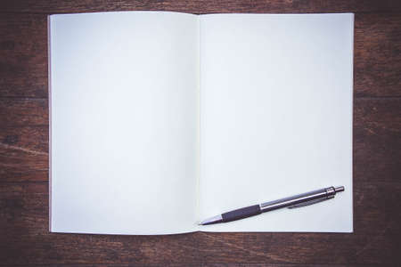 Blank Paper Book On the wood working table Wait for creative time to start , paper blank for text backgroundの写真素材