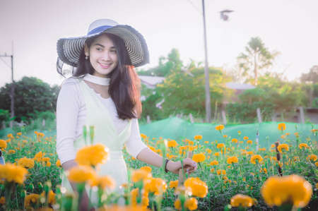 beatiful woman asia style on yellow flower garden and looking smile happy time on the dayの写真素材