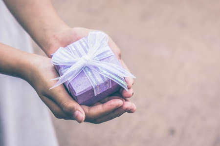 giving gift box in with hands On special days  for special person and copy space backgroundの写真素材