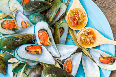Steaming mussel With delicious sauce on dish with wood table seafood styleの写真素材