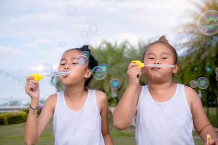 girls happiness funny soap bubble in the park ,Laughing happy with the learning of friendship , lovely sisterの写真素材