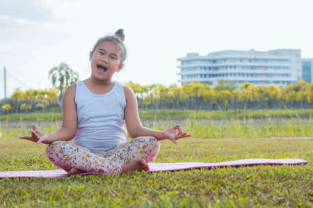 Healthy yoga girls and concentrate in the park , kid Yoga Practice for Health in the nice day , yoga kidの写真素材