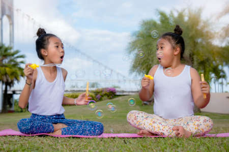 Happy time of friendship , Two kid baby girl play soap bubble Smile and laugh on a bright dayの写真素材