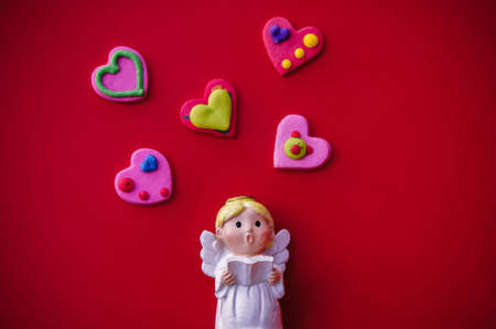 Cupid doll and heart-shaped on red backgroundの写真素材