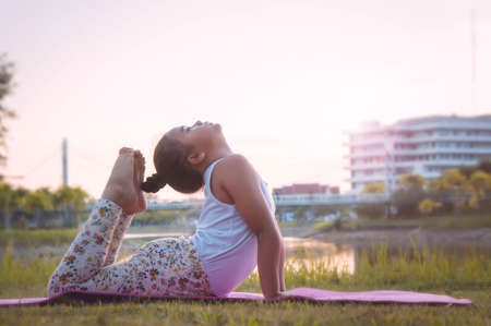 Healthy yoga girls and concentrate in the park , kid Yoga Practice for Health in the nice day , yoga...