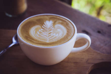 coffee latte white cup on wood table in cafe coffee shop in the morning timeの写真素材