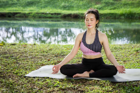 Young woman practicing yoga To strengthen the shape of meditation strength in the morning in the middle of nature.の写真素材