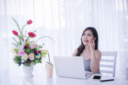 Smart girl's using laptop and happy time on work , smile and laughing time work , workingwomen get think about workの写真素材