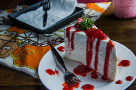 strawberry crape cake on wood table in coffee shop , dessert tasy cakeの写真素材