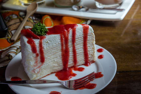 strawberry crape cake on wood table in coffee shop , dessert tasy cakeの写真素材