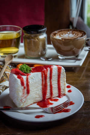 strawberry crape cake on wood table in coffee shopの写真素材