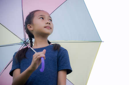 little girl's hold umbrella smile and looking at on the  rainy seasonの写真素材