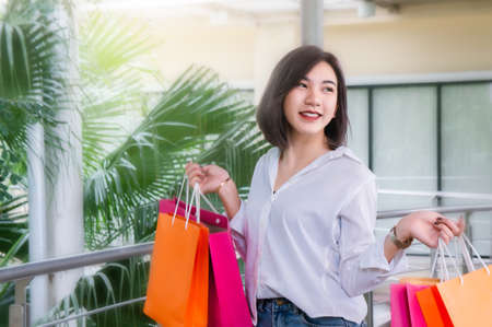 woman smiling and hold shopping bug , she happy time on the day mid year saleの写真素材
