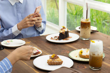 women talking and take a photo dessert and food in cafe restaurant, enjoy eating