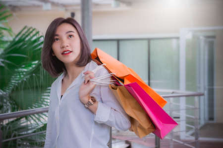 Woman smiling and hold shopping bagの写真素材