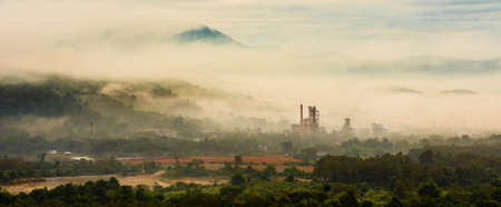 Factory industry in the middle of natural valley in the morning mist
