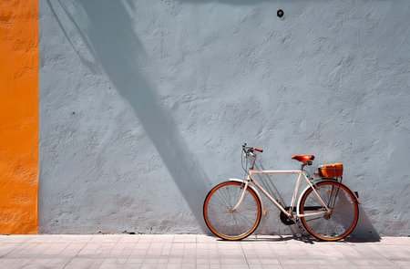 Bicycle on the background of orange wall with shadow from sunlight.の素材