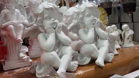 Sitting little angels made of porcelain and other Christmas decorations.
