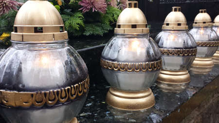 All Saints' Day. Burning large white and gold candles on the tombstone.の写真素材