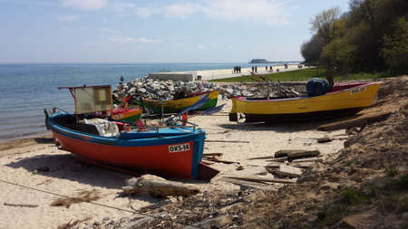 May 14, 2017: Empty fishing boats on the beach. In the background people walk on the boulevardのeditorial素材