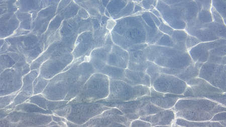 Blue pool water with sun reflections. Background.