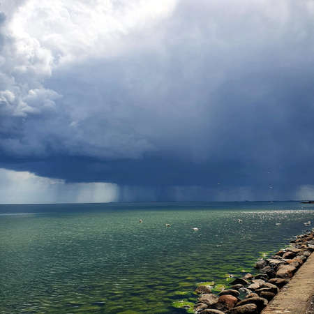 Huge rainy cloud over the sea shoreの写真素材