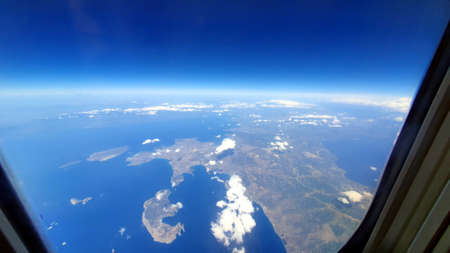 Clouds and earth from behind the airplane window