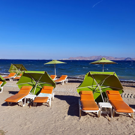 Empty sun loungers with umbrellas on a Greek beachの写真素材