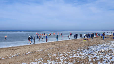 Rewa, Poland - February 22, 2021: Winter swimming. People winter bathing in the sea. A large group of people is walking on frozen water.のeditorial素材