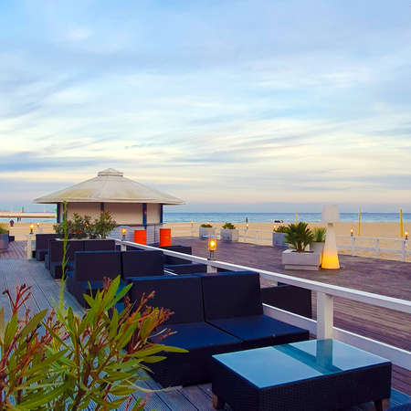 An atmospheric place on the beach. Empty tables and sofas on a wooden landing. Gdynia, Polandの写真素材