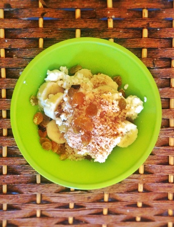 A plate of banana with cottage cheeseytellow raisins and powdered pecanの素材
