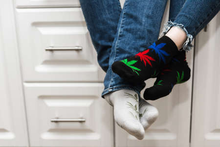 Lovers sit in the kitchen and touch their feet. A guy with a girl. The legs are wearing jeans and...