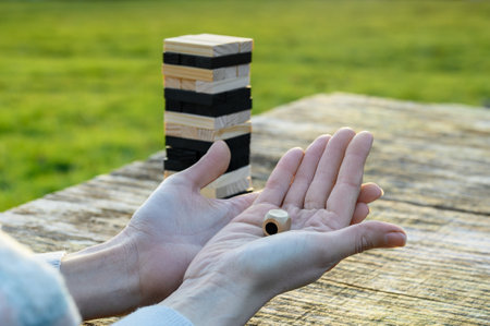 Peaceful rest in nature in sunny weather. The game Jenga, Wooden tower against the background of...
