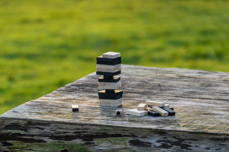 Peaceful rest in nature in sunny weather. The game Jenga, Wooden tower against the background of...