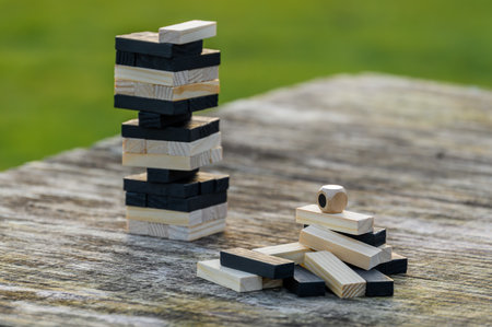 Peaceful rest in nature in sunny weather. The game Jenga, Wooden tower against the background of...