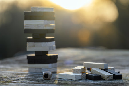 Peaceful rest in nature in sunny weather. The game Jenga, Wooden tower against the background of...