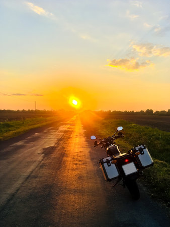 Wild motorcycle trip (Europe, Hungary). Black motorcycle with panniers parked. Grass in the...