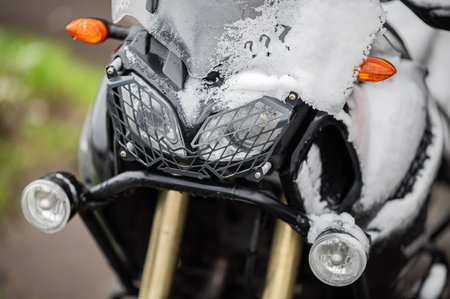 A large black touring motorcycle is covered in snow. The end of the motorcycle season, winter.の写真素材