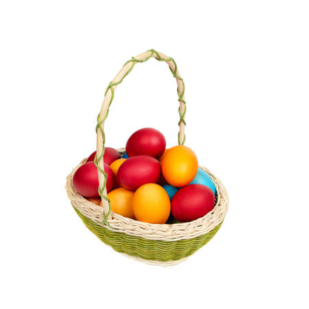 Basket full of hand-painted Easter eggs standing on a wooden surface. isolated on a white backgroundの写真素材