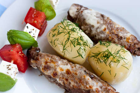 Roasted stuffed pork rolls with potatoesの写真素材