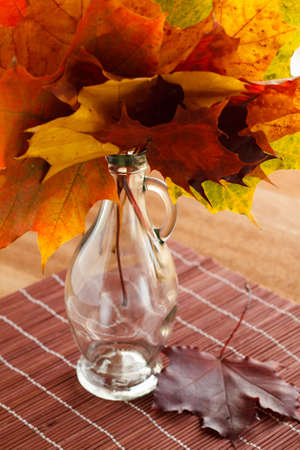 Autumn maple leaves bouquet in a glass bottleの写真素材